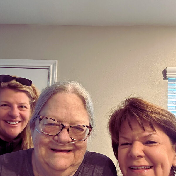 A Bay Area Meals on Wheels client smiling with two volunteers